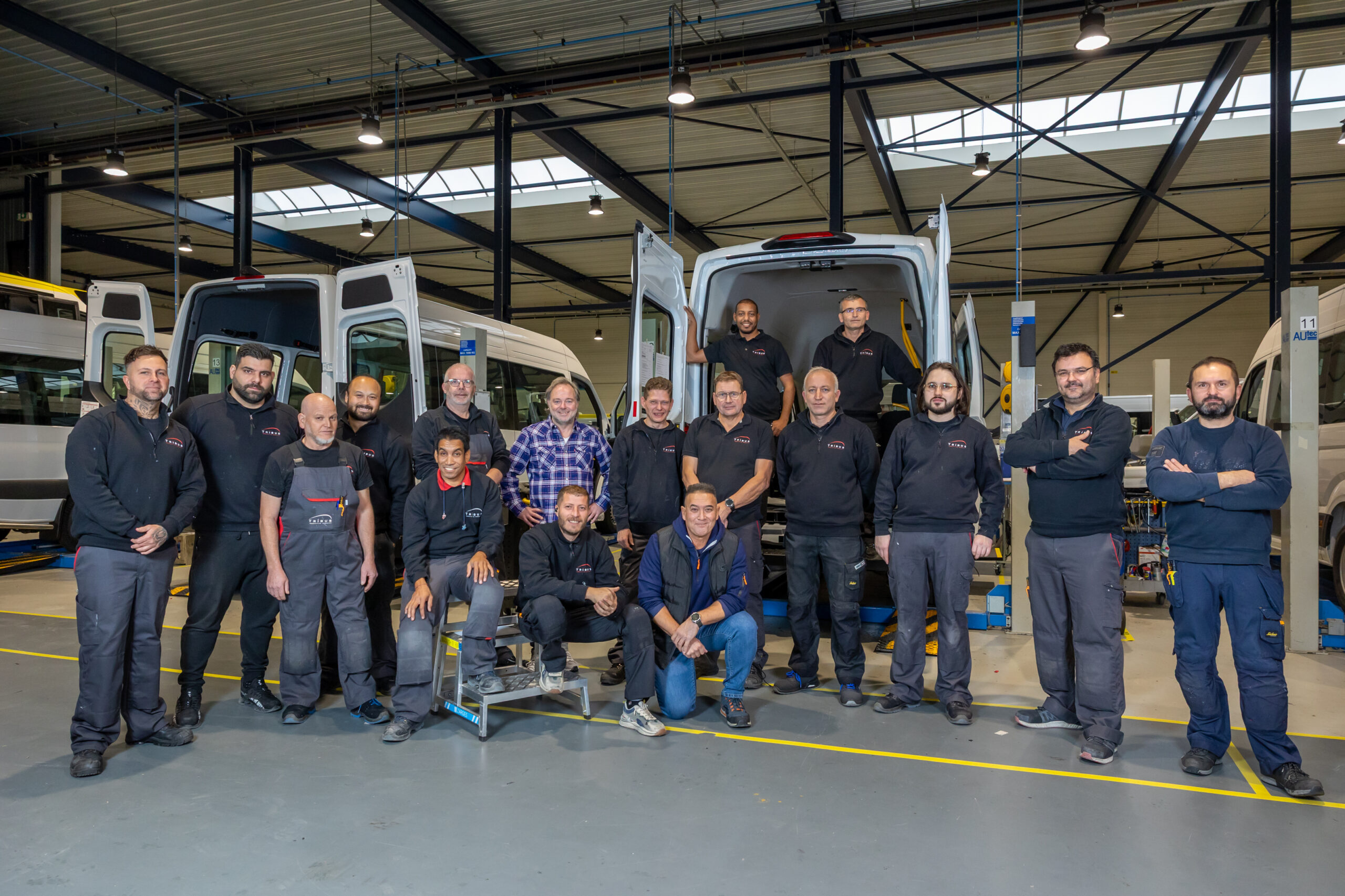 Jonge en ervaren medewerkers delen kennis en werken samen aan voertuigbouw in de werkplaats