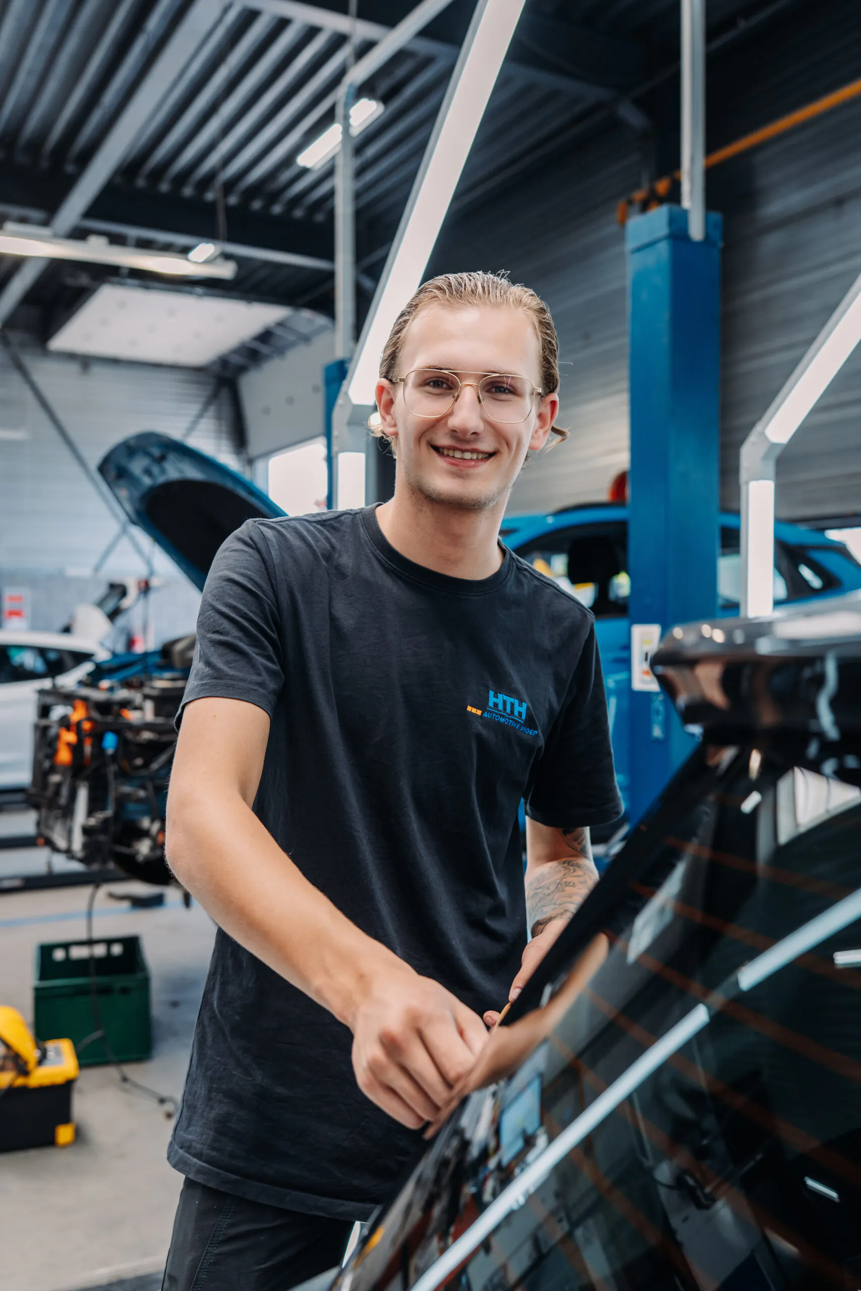 Leerlingen oefenen samen vaardigheden voor de opleiding tot schadehersteller in een moderne werkplaats